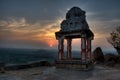 An old ruin of an Hindu Temple in semi silhouette with setting sun in background