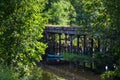 Old ruined bridge overgrown with moss on a Sunny summer day