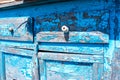 An old ruined chest of drawers with a cracked blue paint close-up. destruction under the influence of nature.