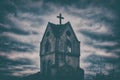 An old ruined Church in the evening gloom. Bell tower of medieval Europe against a gloomy sky. Mystical clouds on grey heaven Royalty Free Stock Photo