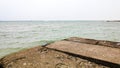 Old ruined concrete pier at a seaside bank, shore after rain at summer vacation. scenic nature landscape Royalty Free Stock Photo