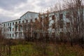 An old ruined dormitory overgrown with trees. Royalty Free Stock Photo