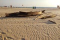 An old ruined fishing boat lies on a sandy beach. Royalty Free Stock Photo