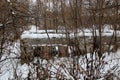 Old ruined house stands surrounded by bushes in winter Royalty Free Stock Photo