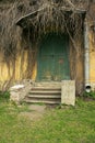 Old ruined porch by house with a wooden door and an old ivy Royalty Free Stock Photo