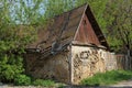 Old ruined rural brown house overgrown