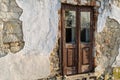 Old ruined wooden door in grungy facade of ruin house Royalty Free Stock Photo