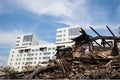 Old ruined wooden house on the background of the new buildings