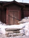 old ruined wooden house with an uninhabited unnecessary building behind a fence with closed Windows a dilapidated abandoned Royalty Free Stock Photo