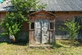 An old ruined wooden house in the village. Details of the facade of a historic wooden house with carved shutters and vintage decor