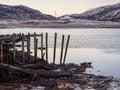 Old ruined wooden pier in the bay of the Barents Sea. Teriberka. Pollution of the coastline Royalty Free Stock Photo