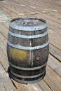 An old Rum Barrel sits on a wooden board walk. old dirty wooden keg or rum barrel