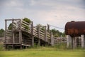 Old run down wooden cattle chute with rusty fuel tank nearby