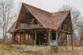 Old rural abandoned wooden collapsing house against cloudy sky in autumn season. Royalty Free Stock Photo