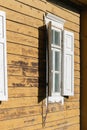 Old rural brown house wall with white window