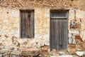 Old rural home facade. Weathered stonewall cottage exterior, wooden brown window and door. Greece Royalty Free Stock Photo
