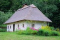 Old rural house with thatched roof and whitewashed walls. Historical village in Ukraine, preserving traditions and culture Royalty Free Stock Photo