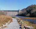 Old rural hydroelectric dam by a river surrounded by thick trees Royalty Free Stock Photo