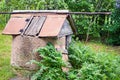 Old rural well close-up. An abandoned well in a thicket of green grass. Selective focus. Royalty Free Stock Photo