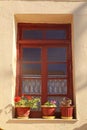 Old rural window with flower pots, Crete, Greece. Royalty Free Stock Photo