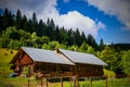 Old rural wooden house with newly built building on hillside with woods Royalty Free Stock Photo