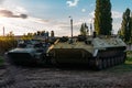 Old Russian armored vehicles on sunset background at military base