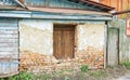 Old Russian brick house in dilapidated condition with boarded-up window