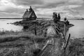 Old russian Orthodox wooden church in the village Rabocheostrovsk, Karelia. Abandoned church on the coastline. Black and