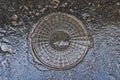 Old russian soviet sewer lid in asphalt Royalty Free Stock Photo