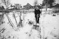 An old russian woman cleans the snow near her house in the village. Black and white photo. Royalty Free Stock Photo