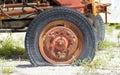 Old rusted abandoned tractor wheel with a flat tire. Very antique tire made in France Royalty Free Stock Photo