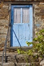 Old rusted blue wooden door and stone house facade