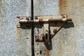 Old rusted grungy metal garage door with latch and hasp Royalty Free Stock Photo