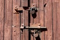 Old rusted grungy wooden garage door with latch and padlock. Royalty Free Stock Photo