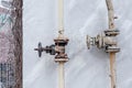 Old rusted iron pipe and control valve on house wall. Royalty Free Stock Photo