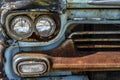 Old rusted metal front grill and bumper of antique classic pickup truck