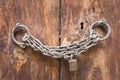 Old rusted padlock, rusted chain, and keyhole on a closed wooden door Royalty Free Stock Photo