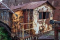 Old rusted train car beside a brick industrial building