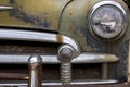 rusted chrome front bumper, headlight and grill of old junk car with peeling paint Royalty Free Stock Photo