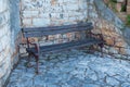 Old rustic bench, natural stone facade and tiles