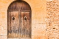 Old brown wooden entrance door and stone wall of mediterranean mansion Royalty Free Stock Photo