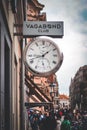 Old, rustic clock hangs from the side of a brick building in Germany