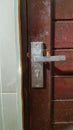 Old rustic dirty steel door knob on a wooden door