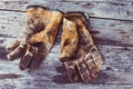 Top view of old rustic and dirty working gloves over wooden table,  gloves for each finger Royalty Free Stock Photo