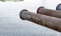 Old rustic dredging pipeline on the river to drainage water Royalty Free Stock Photo