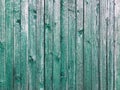 Old rustic fence from boards with green paint.