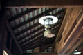 Old rustic lantern is hanging on wooden roof