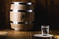 Old rustic oak barrel and glasses of high quality distilled alcohol. Brazilian silver cachaÃÂ§a, called pinga, vodka, white rum, Royalty Free Stock Photo