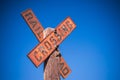 Old, rustic railroad crossing sign, mounted on a wooden pole in a rural setting.