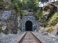 Old and rustic railroad outside a dark tunnel